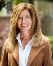 alcohol-treatment-team-denise-becker A confident professional woman involved in alcohol treatment, smiling outdoors.