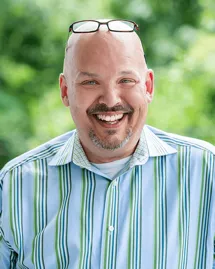 outpatient-rehab-charlotte-nc-counselor-michael-hatley Michael Hatley, Counselor at an outpatient rehab in Charlotte, NC, laughing in a striped shirt.