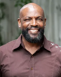 outpatient-rehab-charlotte-nc-lead-counselor-cori-trotman Cori N. Trotman Sr., Lead Counselor at an outpatient rehab center in Charlotte, NC, smiling in a brown shirt.