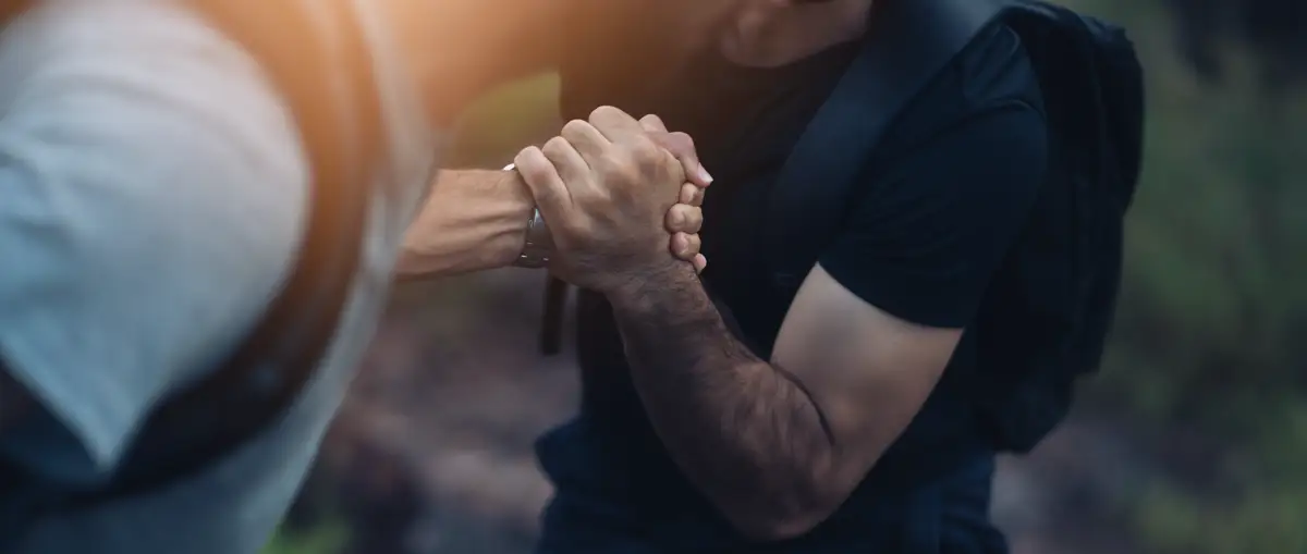 helping-hand-opiate-addiction-recovery A close-up of two hands clasped together in support, representing assistance during the difficult journey of opiate withdrawal and recovery from painkiller addiction.