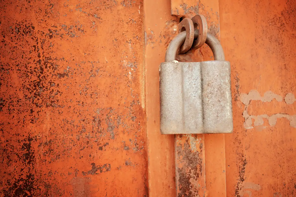 An old padlock on a rusty metal surface, representing the impact of kratom on the liver and health risks.